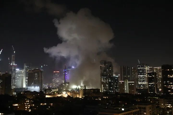 6月13日，在以色列特拉維夫，一棟大樓被導彈擊中後升起濃煙。新華社發（吉德翁·馬科維奇攝/基尼圖片社）