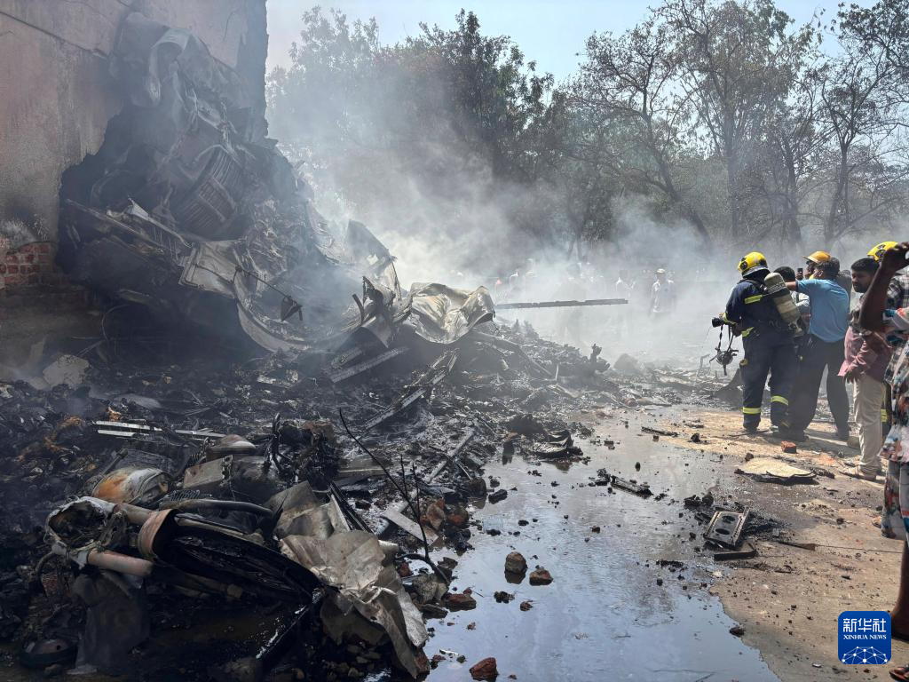 救援人員在墜機現場射水降溫。（新華社）