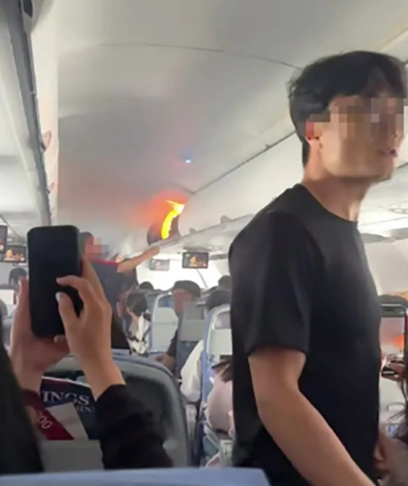 機艙內煙霧瀰漫，乘客驚慌尖叫，有韓籍乘客用韓文高喊「快點」，乘務員迅速拿滅火器撲救，部分乘客也接力協助​。(圖：視頻翻攝)