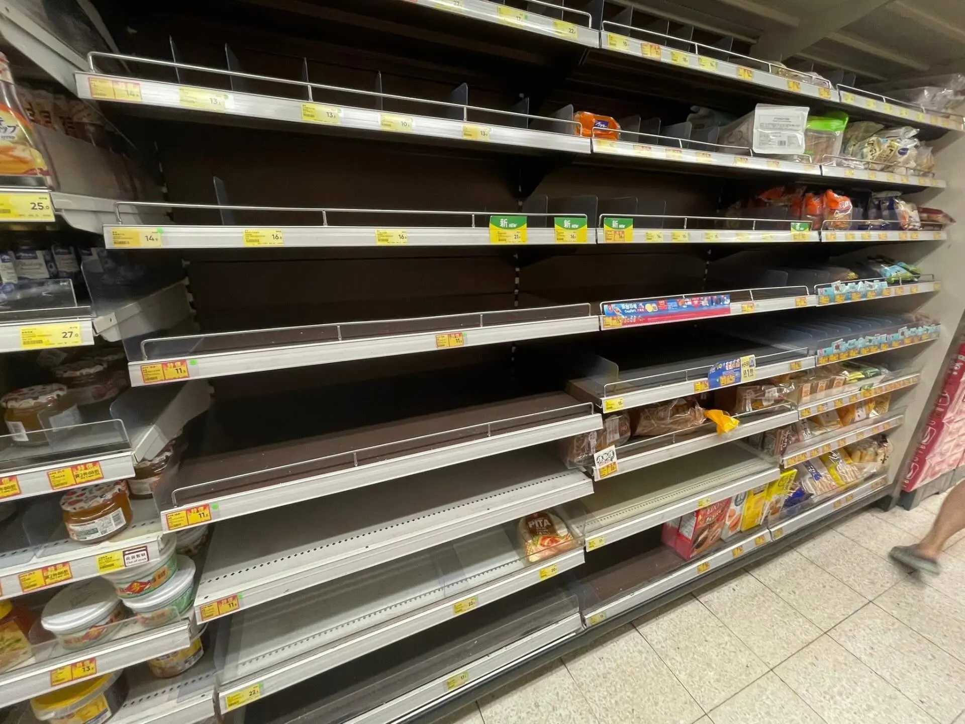 麵包等貨架幾乎被一掃而空，有人形容場面「場面誇張」。(圖： 網絡截圖)