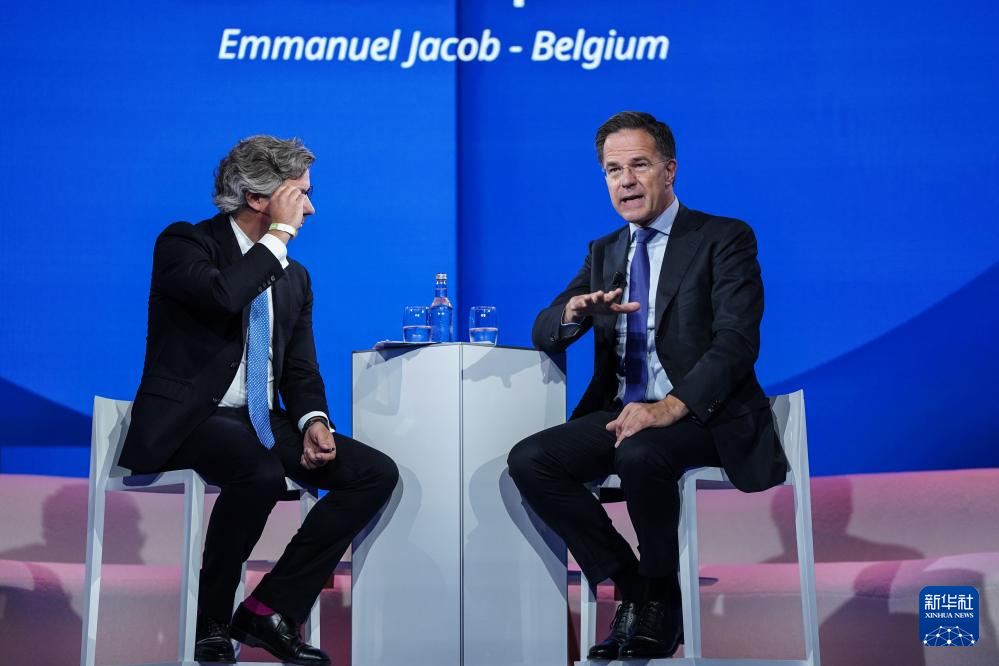 6月24日，在荷蘭海牙，北約秘書長呂特（右）在北約公共論壇上講話。（新華社）