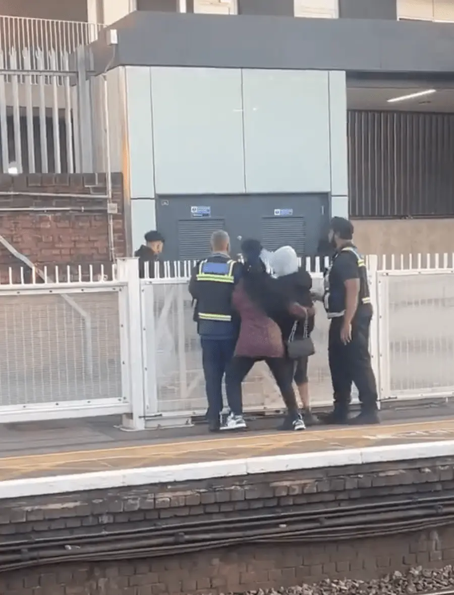 持機的青年突然做出突發舉動，迅速將手機拋過月台圍欄，交給早已在站外等候接應的同夥，接應者接到手機後立刻拔足狂奔。(圖：視頻翻攝)