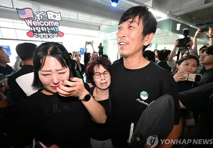 獲釋返國的韓國工人與家屬相擁而泣 (韓聯社)