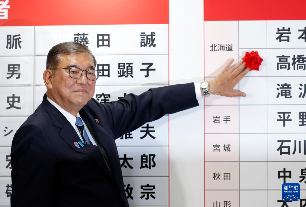 7月20日,在日本東京自民黨總部,日本首相、自民黨總裁石破茂為當選議員貼花。新華社發(Pool圖片,弗蘭克·羅比雄攝)