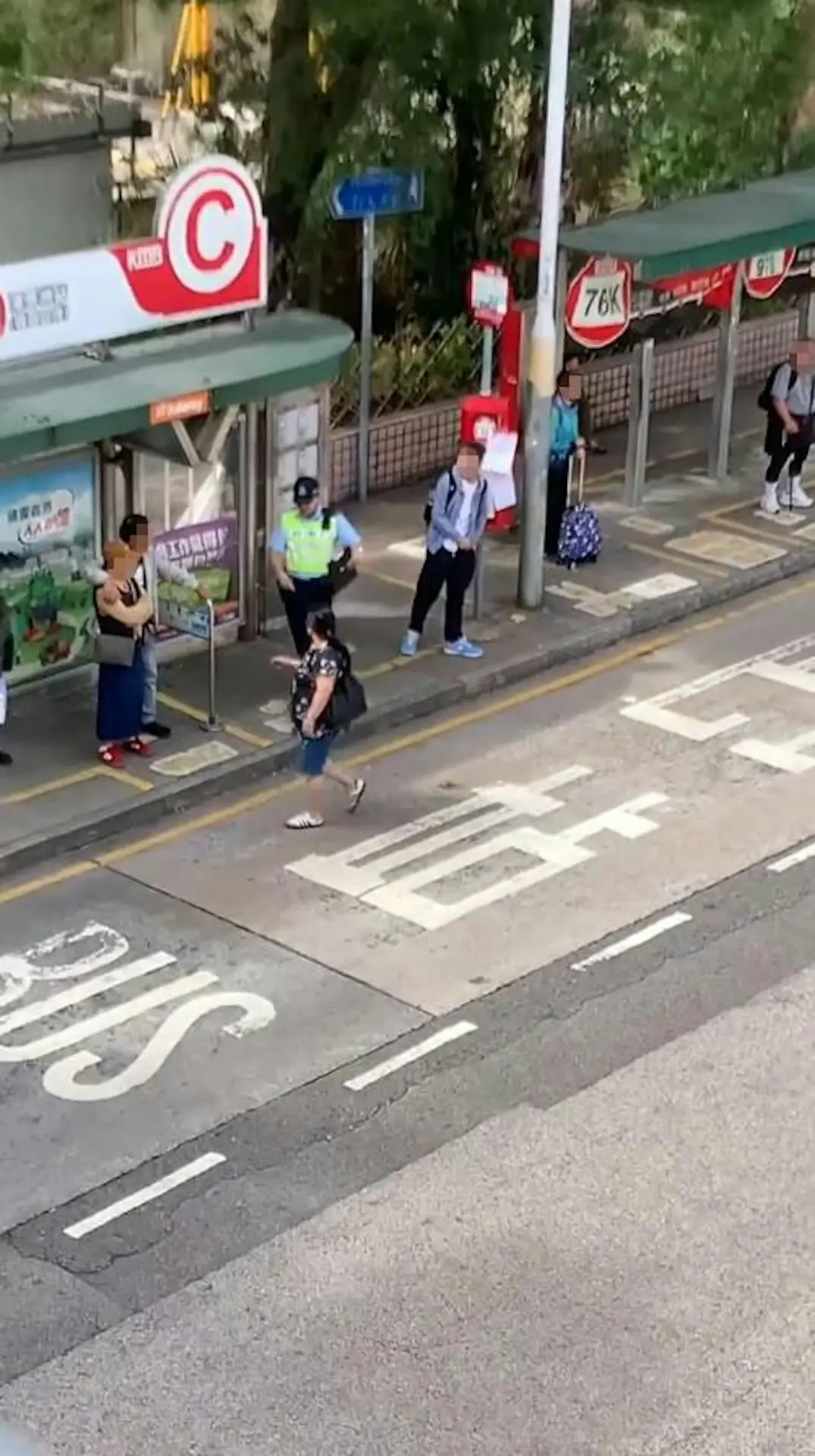 就在她即將踏上巴士站旁的行人路時，一名埋伏在巴士站後方的男警員即時「現身」上前。令人意外的是，婦人見到警員後並未即時停下，反而揮動了一下手，隨即繼續前行。(圖：asiaidiotdrivers@Threads)