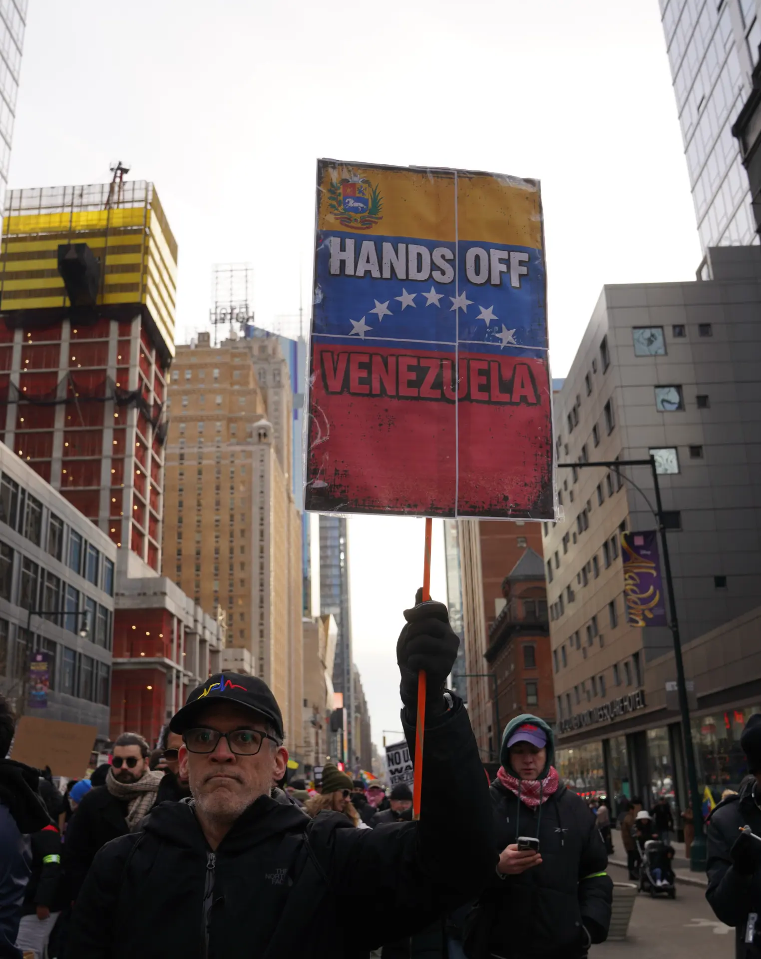 抗議民眾舉起標語，高喊「停止對委內瑞拉的轟炸」「停止為了石油而導致的流血犧牲」等口號，強烈譴責美國以霸權干涉他國內政。(圖：新華社)