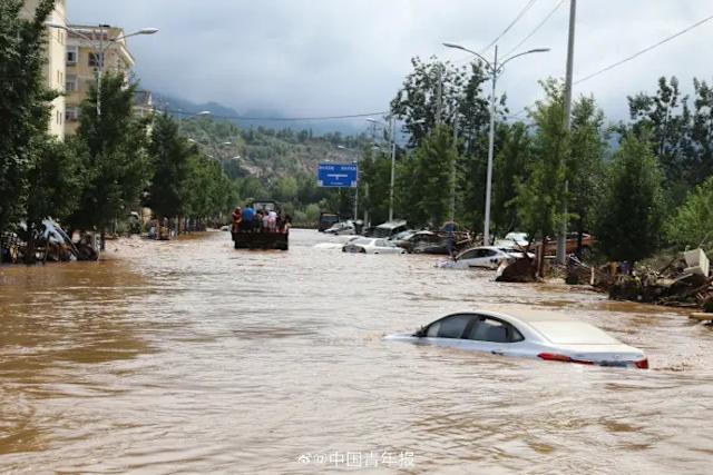 北京市密雲區太師屯鎮附近社區遭遇山洪，28日救援人員出動救援。（翻攝自微博／北京青年報）