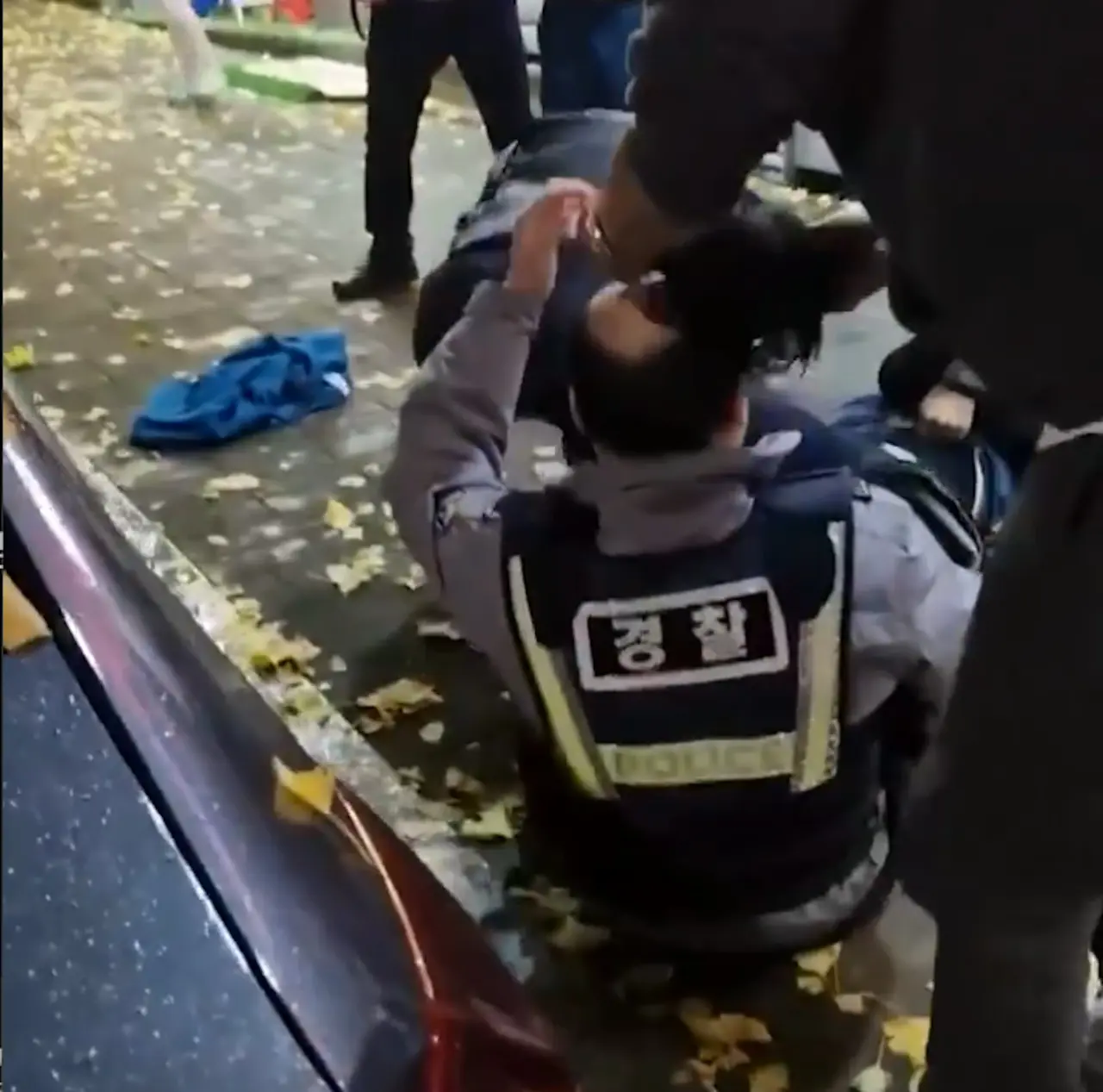 韓國釜山警員街頭合力壓制滋事醉漢時，突發假髮脫落的頭頂意外。一旁路人默默幫忙戴回，嚴肅的執法場面秒變爆笑喜劇反差名場面，影片於網路瘋傳引發熱議。（來源：GONI_GOOD@X）