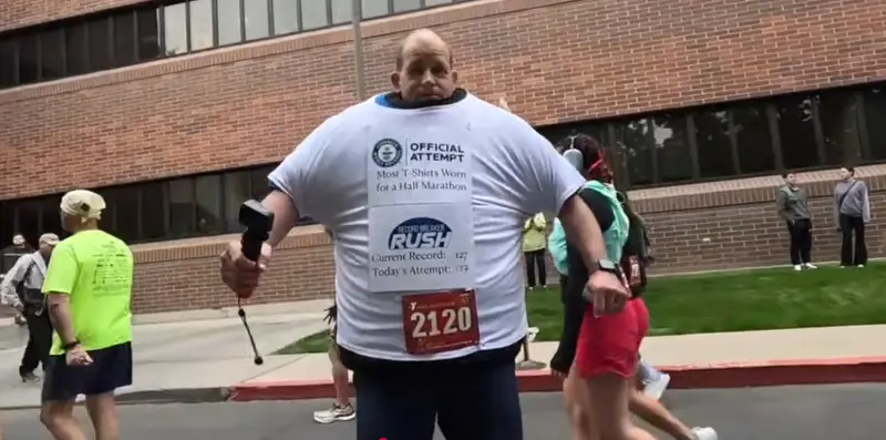 美國愛達荷州男子David Rush，為奪回曾失去的「穿最多T恤跑半馬」金氏紀錄，克服重量與血液循環等難題，穿48磅（約21.7公斤）的137件T恤，順利完成愛達荷馬鈴薯半馬，刷新紀錄。（視頻截圖來源：RecordBreakerRush@YouTube）