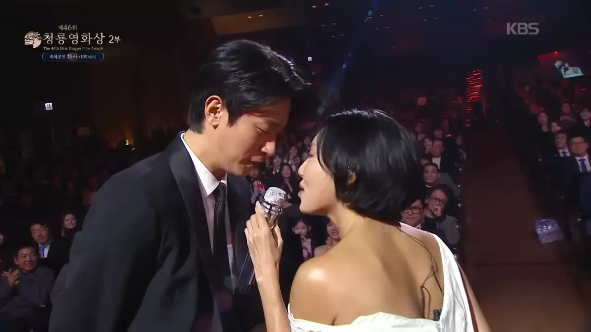 當晚，MAMAMOO出身的華莎身著一身白色貼身長禮服，赤腳踏上舞台獻唱個人新歌〈Good Goodbye〉。她獨特渾厚的磁性嗓音剛響起，便瞬間征服全場，而台下一個熟悉的身影更讓粉絲屏息——以電影《醜得要命》入圍本屆最佳男主角的朴正民。(圖：視頻截圖)