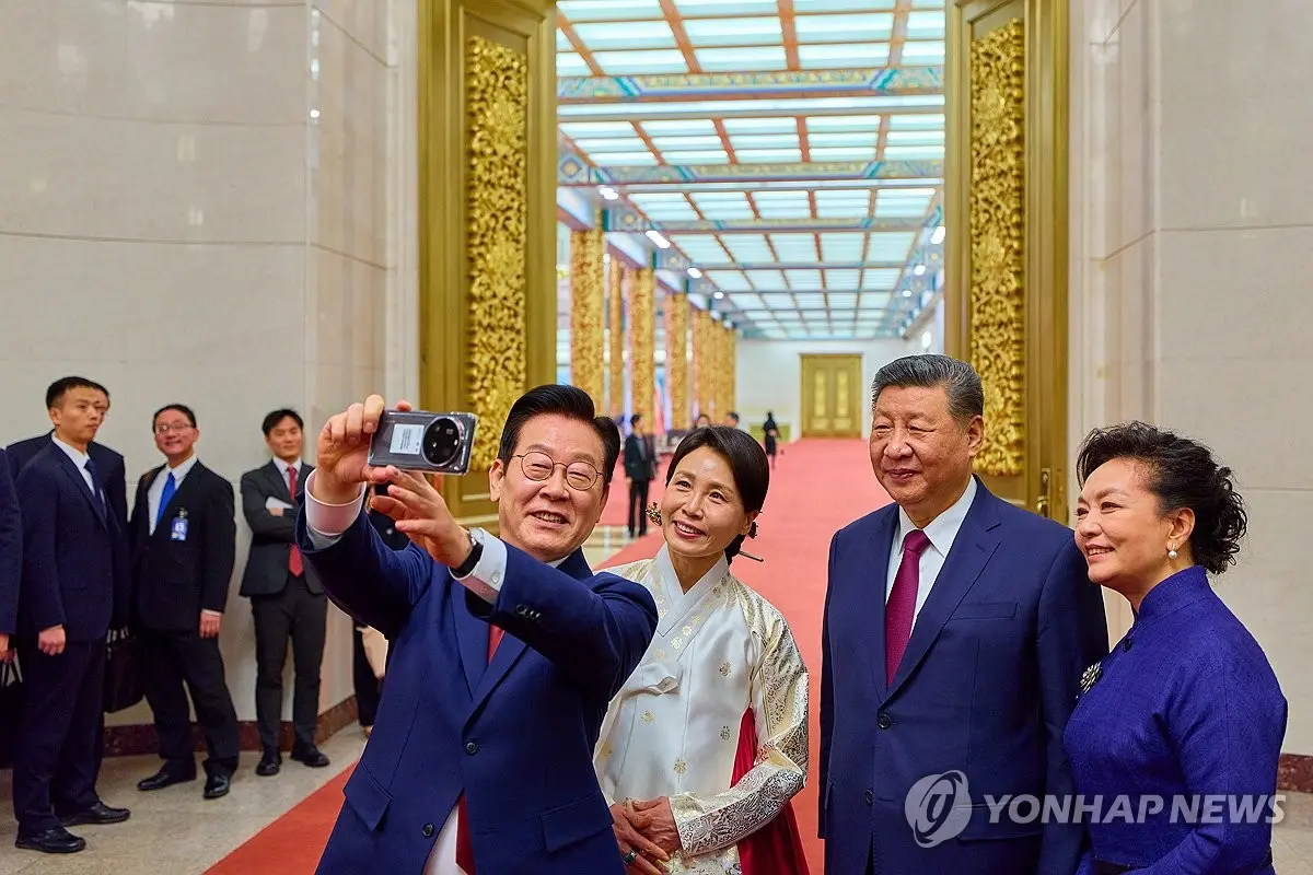 1月5日，在北京人民大會堂，李在明（左一）和夫人金惠景（左二）同習近平夫婦自拍。 韓聯社聯合採訪團