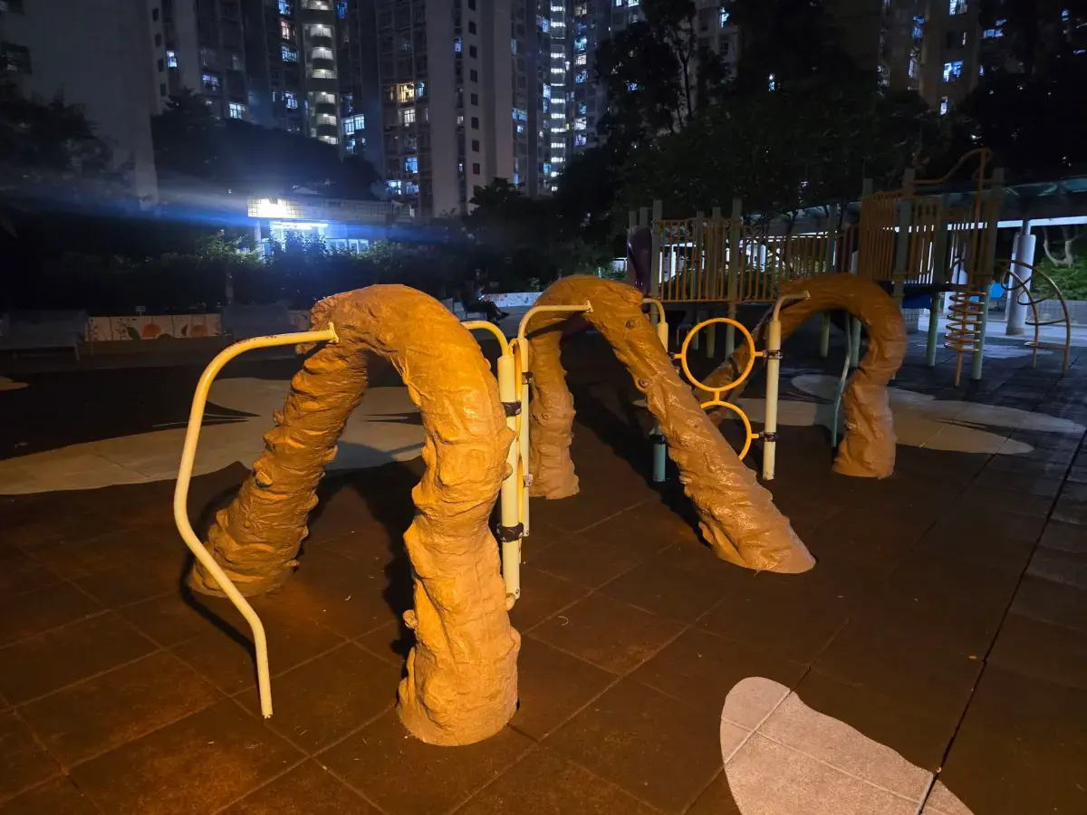 香港慈雲山慈安苑附近遊樂場一款攀爬設施爆熱議，深褐色拱形柱體造型神似排泄物，視覺效果尷尬，遭網民瘋狂吐槽，更打趣致敬HYROX，實用性與安全性也備受質疑。（來源：慈雲山資訊交流臉書社團）